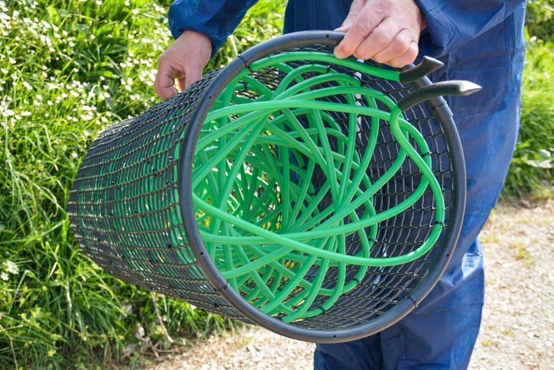 Le fluide caloriporteur circule dans des tuyaux en plastique (verts). Ce capteur est placé dans une cage grillagée, elle-même en plastique pour éviter toute corrosion. Celle-ci est installée dans la cheminée (fixation simple) où les calories sont récupérées dans l'air chaud extrait. Ces calories sont dirigées via les tuyaux vers le compresseur à l'extérieur de la salle, dans le couloir de circulation. Elles sont ensuite restituées dans la salle grâce aux brasseurs, équipés de petits ventilateurs pour assurer une température homogène. Le système est simple, sans carte électronique. Il s'adapte à tout type de salle. - Illustration Bâtiment porc : un capteur de calories dans la cheminée