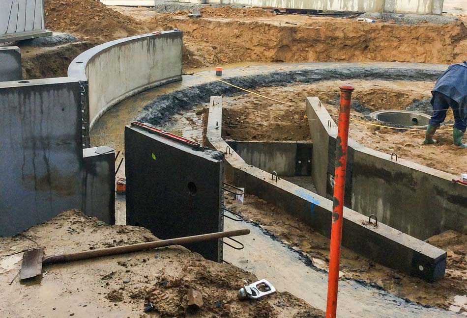 L'espace traite en construction. À noter, la fosse, à l'emplacement du futur plancher amovible pour s'adapter à la taille des trayeurs. Tous les murs sont préfabriqués. - Illustration Un chantier rapide et propre, en préfabriqué