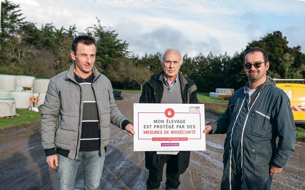 Les éleveurs Didier Coëffec et Erwan Calle encadrent Félix Mahé. Ils présentent le panneau qui sera remis aux participants aux formations et ateliers biosécurité du GDS Bretagne. - Illustration La biosécurité s’invite dans les élevages bovins