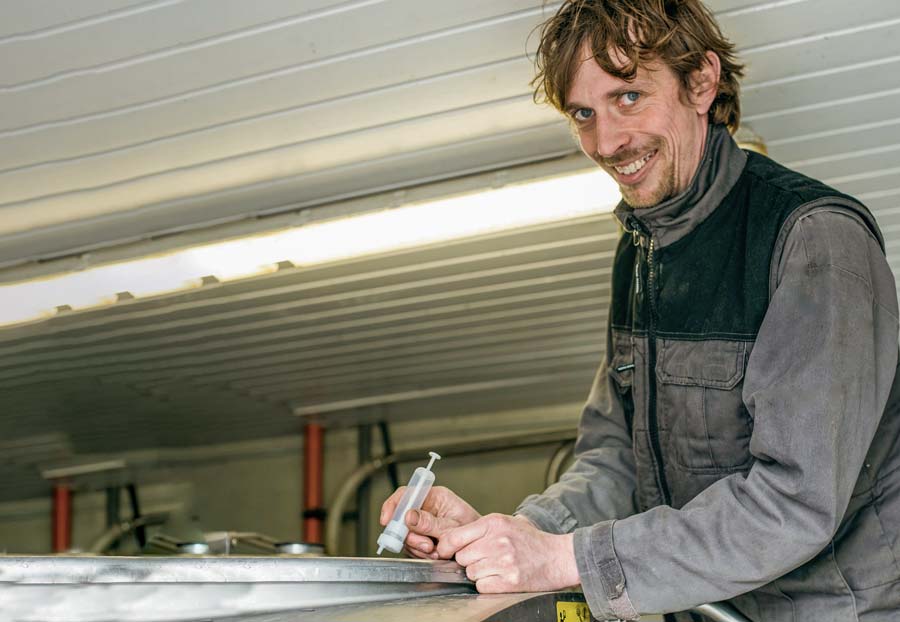 Grâce à une seringue, tous les 15 jours, Grégory Breton prélève un échantillon d’une traite dans le tank. Suite au génotypage de toutes les vaches, ce lait de mélange va permettre de déterminer en laboratoire le taux cellulaire de chaque animal. - Illustration Suivre le taux cellulaire de près grâce à l&rsquo;ADN