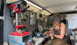 Dans sa camionnette - atelierne, une rémouleuse en train d'affûter une lame.