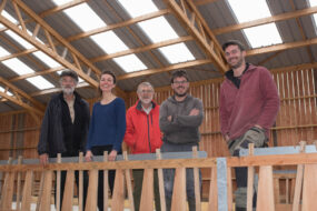 Cinq personnes dans une bergerie en construction