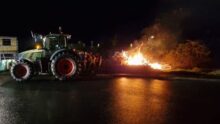 Feu de colère dans la nuit avec un tracteur à côté