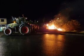 Feu de colère dans la nuit avec un tracteur à côté