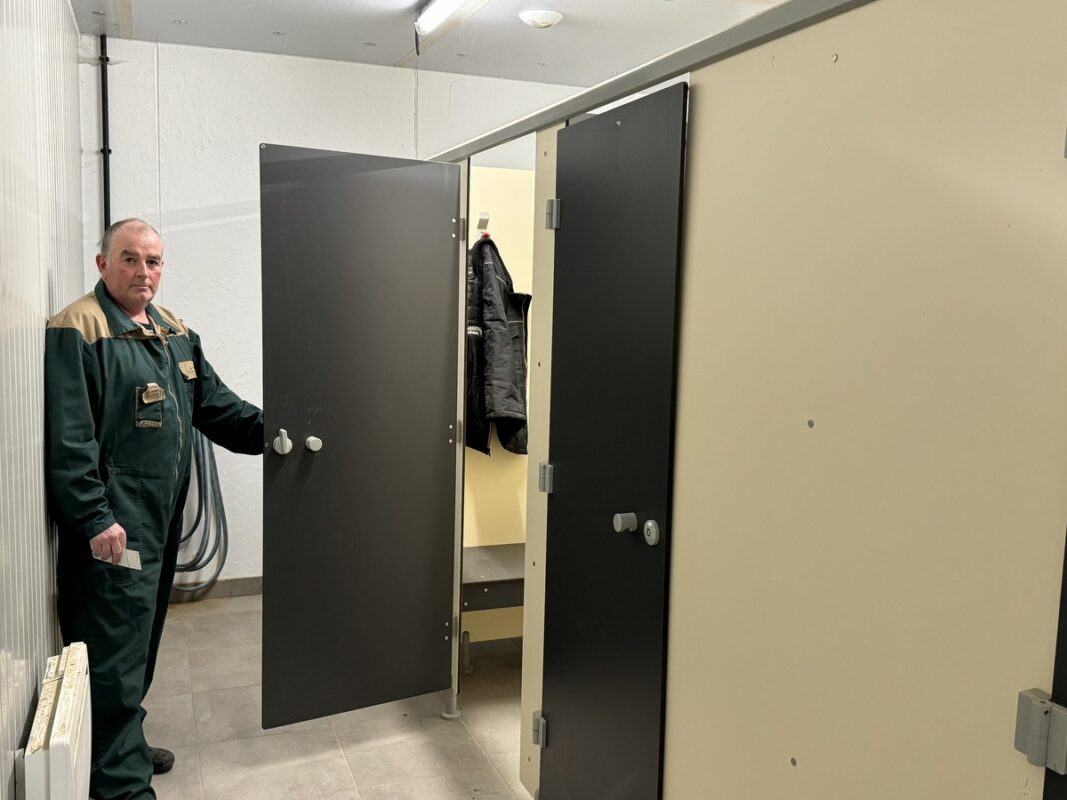 Un salarié agricole ouvre la porte de son vestiaire.