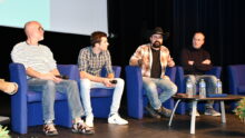 Les quatre intervenants en table ronde dans la salle de conférence