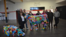 Des personnes devant des statues de vaches et de cochon