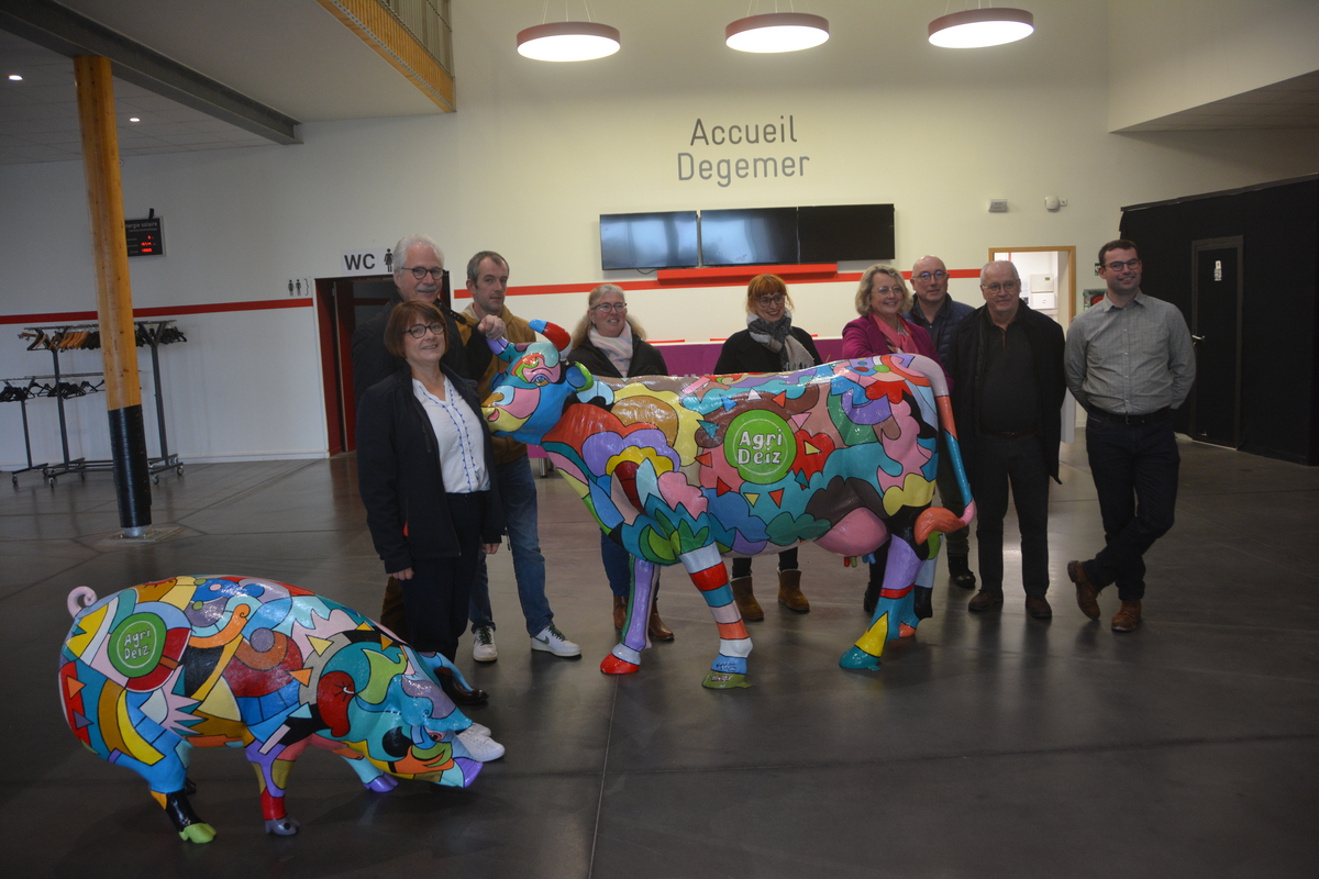 Des personnes devant des statues de vaches et de cochon - Illustration En route pour Quimper