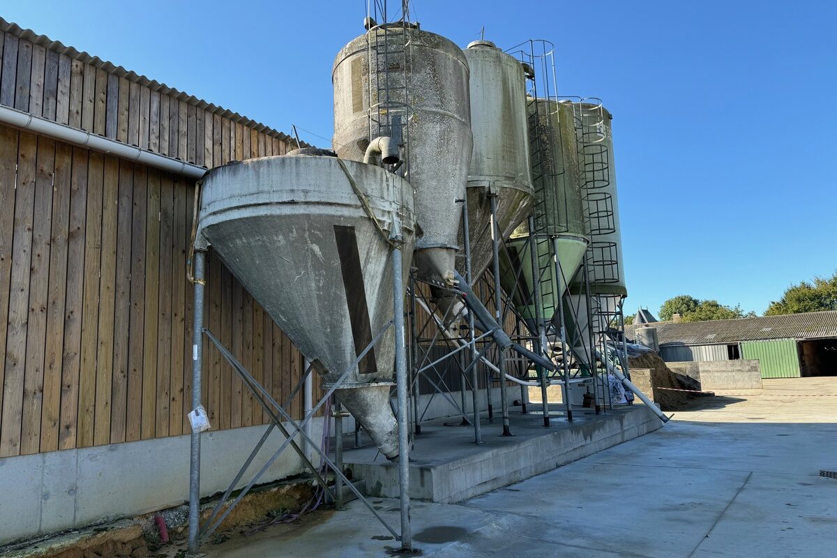 Des silos d'aliments à côté d'un bâtiment d'élevage laitier - Illustration Se faire accompagner gratuitement pour réduire ses charges opérationnelles