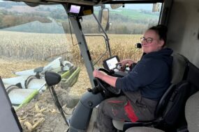 Une jeune femme au volant dans une cabine de moissonneuse