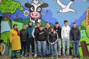 Des élèves et leur professeure devant une fresque
