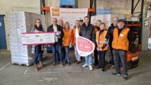 Un groupe de personnes pour la remise d'un don de 15 000 côtes de porc à des Banques Alimentaires