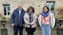 deux femmes et un hommes devant une maison