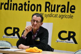 Joseph Martin devant une affiche de la Coordination rurale