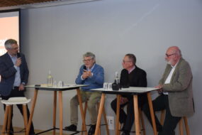quatre hommes à une tribune