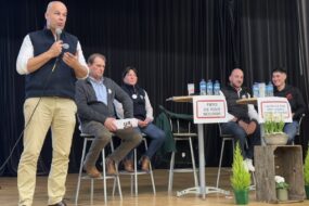 Quatre hommes et une femme à la tribune d'un meeting syndical de la FDSQEA - JA des Côtes d'Armor