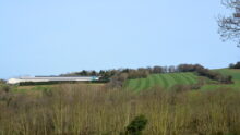 Paysage agricole breton avec bâtiment avicole et culture