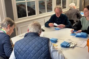 Quatre personnes en train de dépouiller des bulletins de vote.