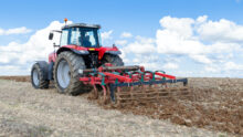 tracteur dans un champ travaillant le sol