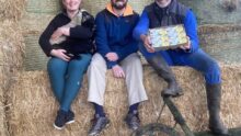 Les éleveurs de la bergerie de la Corbière sur une botte de paille