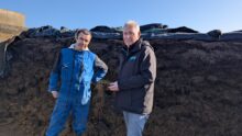 2 hommes devant un ensilage d'herbe