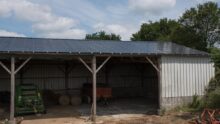 Un hangar de stockage de matériel agricole avec des panneaux photovoltaïques en toiture