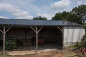 Un hangar de stockage de matériel agricole avec des panneaux photovoltaïques en toiture