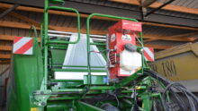 Réserve d’eau et d’inoculant SLV Applipro installée à l’avant d'une presse enrubanneuse.