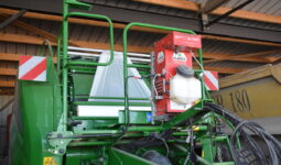 Réserve d’eau et d’inoculant SLV Applipro installée à l’avant d'une presse enrubanneuse.