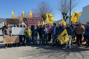Un groupe de personnes avec des drapeaux jaunes du syndicat Confédération Paysanne