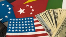 Les drapeux américain, chinois, européen et une liasse de dollars