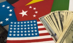 Les drapeux américain, chinois, européen et une liasse de dollars