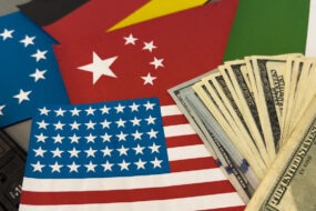 Les drapeux américain, chinois, européen et une liasse de dollars