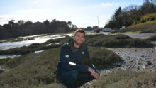 Ewen Frin en train de récolter des herbes marines sur une plage