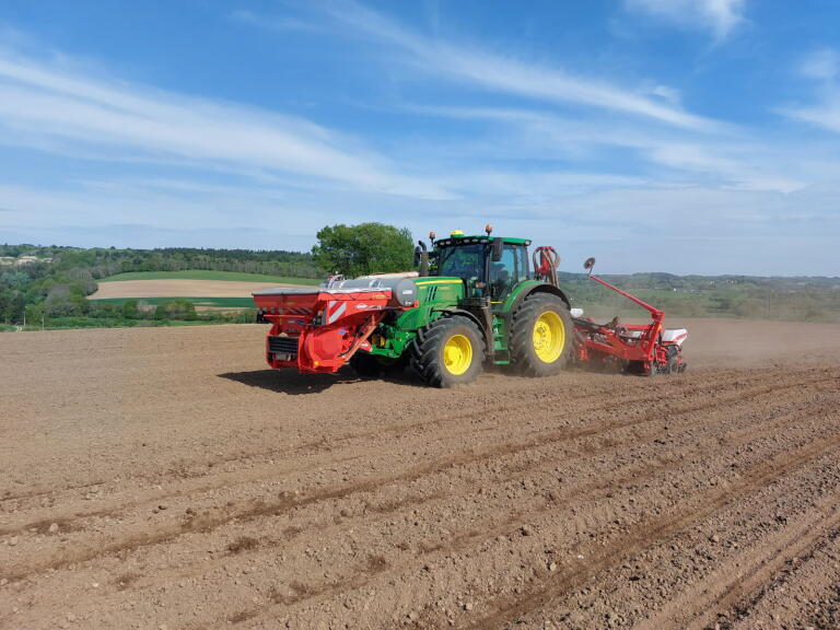 Un tracteur dans un champ en train de semer du maïs - Illustration Choisir une ETA agréée pour semer son maïs