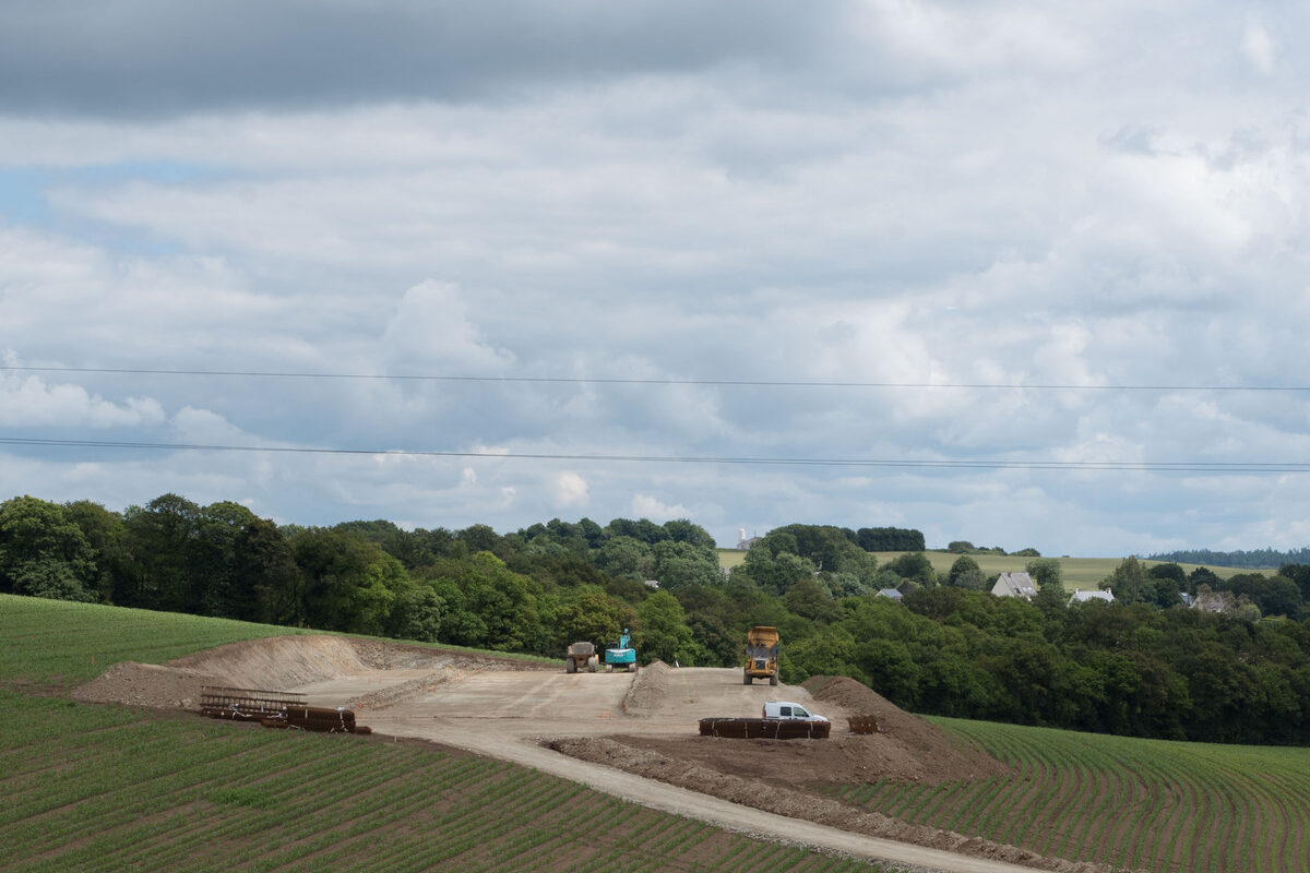 Un chantier de terrassement de bâtiment agricole au milieu de champs de maïs - Illustration Production laitière : Bien chiffrer son projet bâtiment