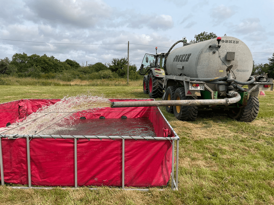Une tonne à lisier remplit d'eau approvisionne une réserve installée par les pompiers.  - Illustration S’engager pour aider  les pompiers