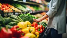 Un étal de légumes avec une personne en train de se servir