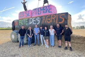 Des personnes devant une structure de paille