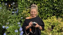 Une femme tenant un appareil photographique dans les mains.