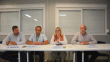 Quatre personnes assises à une table face à une assemblée
