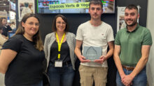 Un groupe de personne dont un tient un trophée dans ses mains