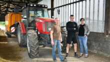 une femme et deux hommes devant un tracteur