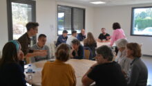 Des personnes dans une salle de réunion autour de tables rondes