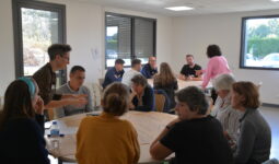 Des personnes dans une salle de réunion autour de tables rondes
