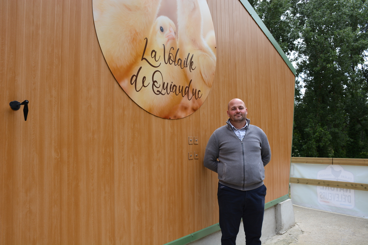 Un homme devant un bâtiment avec une enseigne d'élevage de volailles - Illustration Se lancer en volaille de chair