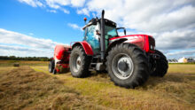 Un tracteur au travail dans un champ avec une presse