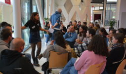 un groupe de personnes face à une exposante sur un salon