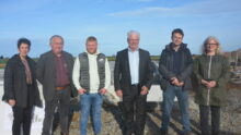 Des personnes devant le chantier de construction d'une porcherie