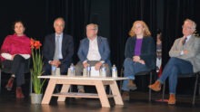 Cinq personnes à une tribune